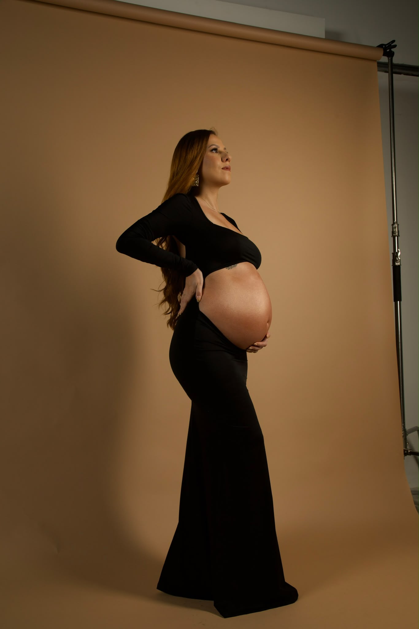 Beatriz Serpa in a black dress during a maternity portrait session