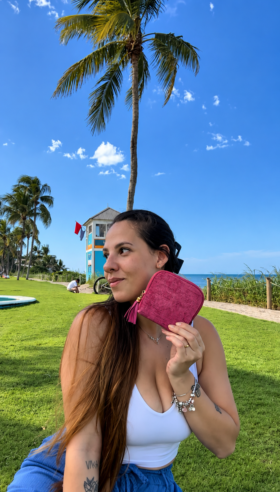 Beatriz holding a pink jewelry organizer outdoors by the beach